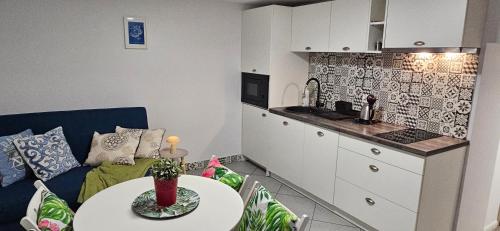 a living room with a couch and a table and a kitchen at Willa Joanna in Gdańsk