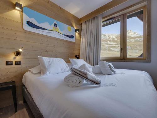 ein Schlafzimmer mit einem Bett mit Handtüchern darauf in der Unterkunft Appartement moderne 7 pers. avec babyfoot, buanderie et vue sur le lac - FR-1-641-2 in Tignes