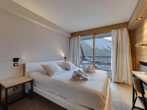une chambre avec un lit et une grande fenêtre dans l'établissement Appartement moderne au cœur de Tignes, 2 chambres, balcon, WiFi, linge fourni - FR-1-641-3, à Tignes
