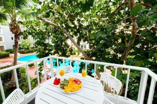 a table with a bowl of fruit on a balcony at LOS COCOS - tropical studios and suites - LOS CORALES beach in Punta Cana