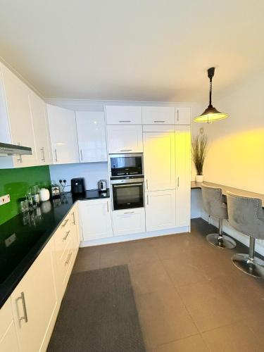 a kitchen with white cabinets and a stove top oven at 200m to Wembley Stadium Guest Rooms in London