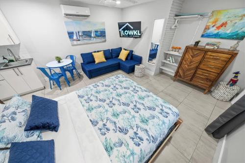 a living room with a blue couch and a table at Casa Cordova Apartments By Lowkl in Fort Lauderdale
