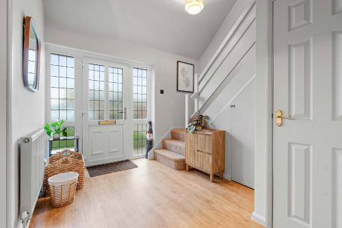 a hallway with a white door and a staircase at Cosy 3 Bed with Parking in Bilton