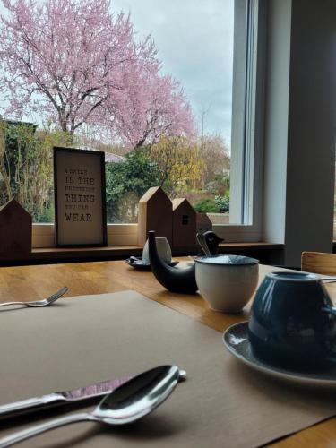 un tavolo con un piatto e un cucchiaio e una finestra di Hotel Scholz ad Aalen