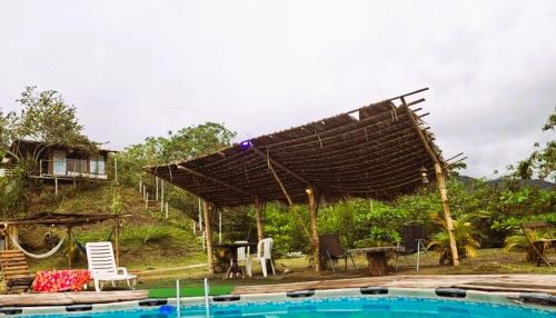 un gran techo de madera sobre una piscina con una casa en Eco Ortalis Villeta, en Villeta