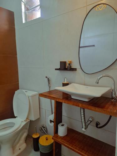 a bathroom with a sink and a toilet and a mirror at Wind Village Icaraizinho in Icaraí