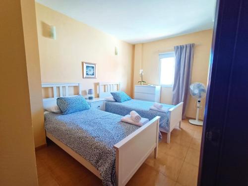 ein kleines Schlafzimmer mit zwei Betten und einem Fenster in der Unterkunft Miramar 2 in San Sebastián de la Gomera