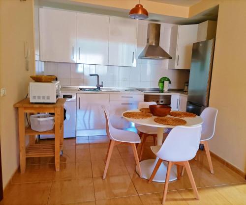 eine Küche mit weißen Schränken und einem Tisch und Stühlen in der Unterkunft Miramar 2 in San Sebastián de la Gomera