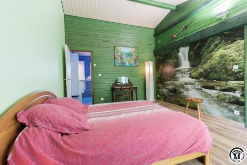 a bedroom with a pink bed with a painting on the wall at En savanac in Albiac
