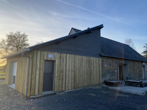 un grand bâtiment en bois avec un grand garage dans l'établissement Le Nid, à Abbaretz