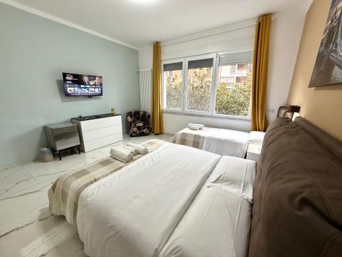 une chambre avec deux lits et une télévision dans l'établissement Desire guest House, à Pise