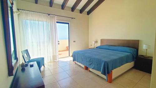 a bedroom with a blue bed and a large window at Casa Micaela - Exclusive in Playa de Santiago