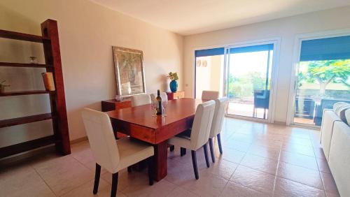 a dining room with a wooden table and white chairs at Casa Micaela - Exclusive in Playa de Santiago