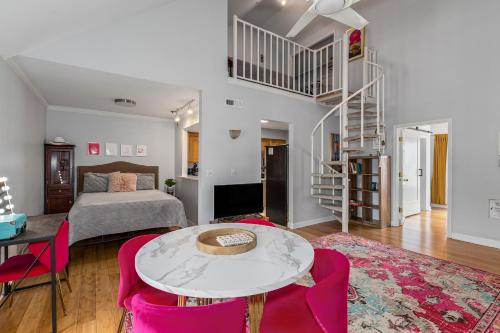 a living room with a bed and a table and pink chairs at The Fancy Nancy in Nashville