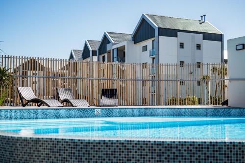 a fence with a pool in front of a house at Costa Bella in Gqeberha