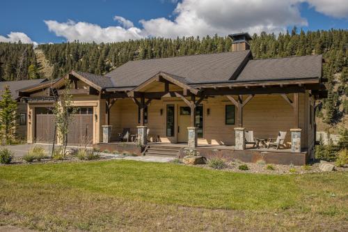 a log home with a porch and a house at Spanish Peaks - Highlands Cabin 59 in Big Sky