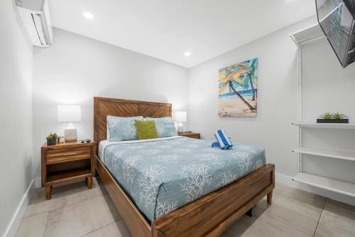 ein Schlafzimmer mit einem Bett mit einem hölzernen Kopfteil in der Unterkunft Casa Cordova Apartments By Lowkl in Fort Lauderdale