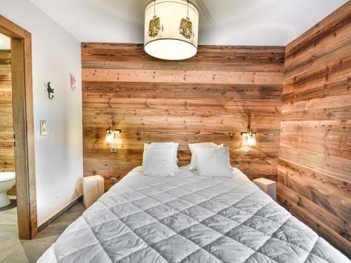 a bedroom with a large bed with wooden walls at Chalet 3 chambres - Sauna et salle de sport - 8 pers - FR-1-685-91 in Les Gets