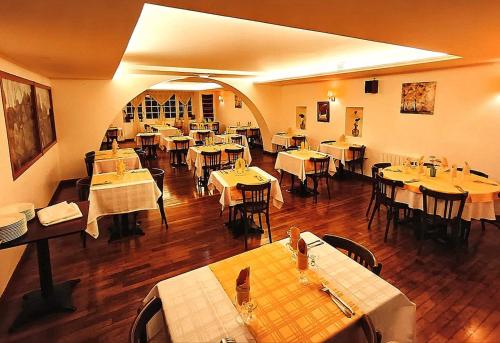 een eetkamer met tafels en stoelen in een restaurant bij Hôtel Restaurant Le Bretagne in Huelgoat