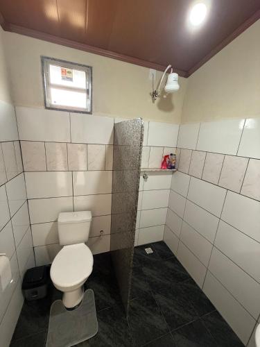 ein Badezimmer mit Toilette und Fenster in der Unterkunft Recanto Zechini in Vargem Alta