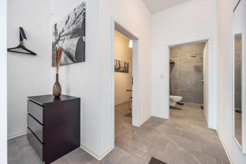a hallway with a bathroom with a toilet and a dresser at Altenbeken- Ferienwohnung 1 in Altenbeken