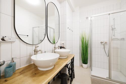 a bathroom with two sinks and a shower at Operastreet Residences - Big Business Apartment in Vienna
