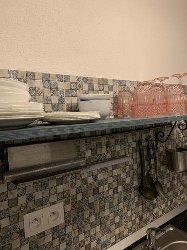 une étagère dans une cuisine avec des assiettes et des ustensiles dans l'établissement chata Modrá, à Vinné