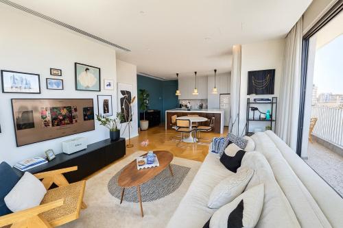a living room with a white couch and a tv at Penthouse Living in the Heart of Nicosia in Nicosia