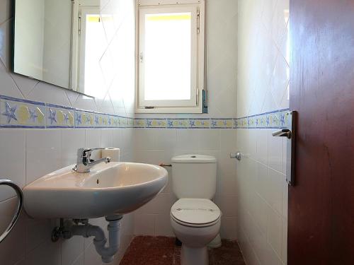 ein Badezimmer mit Waschbecken und Toilette und einem Fenster in der Unterkunft Casa con Jardín a 100m de la Playa de la Farella, Wifi y Garaje Privado - ES-228-175 in Llança