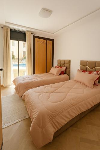 Voodi või voodid majutusasutuse Appartement bord de mer avec piscine à Bouznika toas