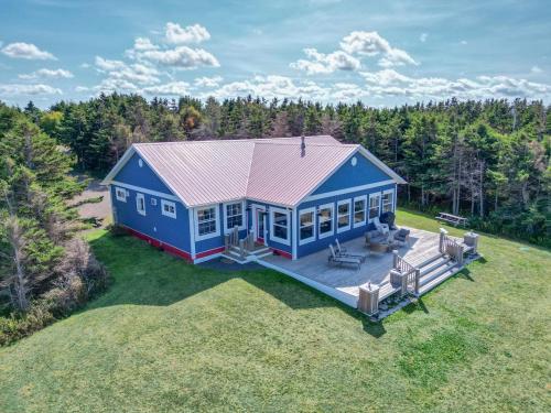 eine Draufsicht auf ein blaues Haus auf einem Feld in der Unterkunft Ocean Dream Beach House in Saint Peters