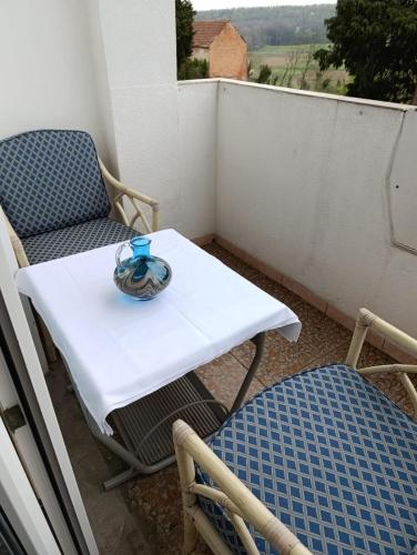 ein weißer Tisch und zwei Stühle auf einem Balkon in der Unterkunft Apartman Kepić in Sirova Katalena