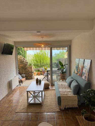 ein Wohnzimmer mit Sofa und Tisch in der Unterkunft Cozy apartment in Bormes-les-Mimosas