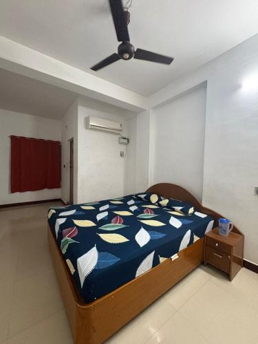 Un dormitorio con una cama con un edredón azul. en Suriya Inn, en Tiruchchirāppalli