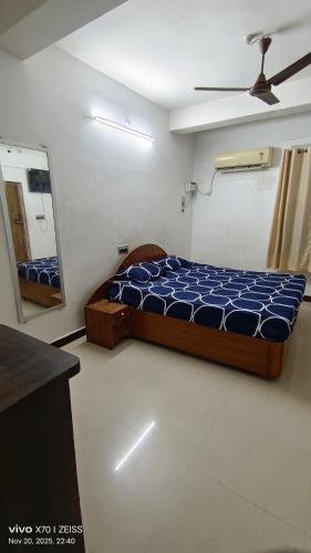 un dormitorio con una cama y un espejo en Suriya Inn, en Tiruchchirāppalli