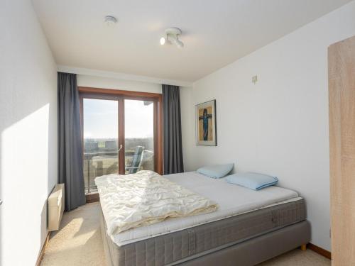 a bedroom with a bed and a large window at Dunekant - 0203 + park.6 in Miami Wijk