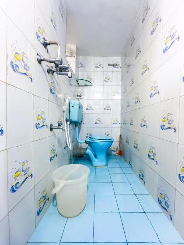 a bathroom with a blue toilet in a room at IVON Guest House Arambol in Arambol