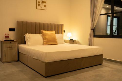 a bedroom with a bed with white sheets and gold pillows at Villa EN 22 in Galle