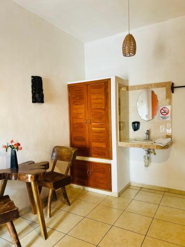 a dining room with a table and a sink at Hotel Szapot in Bacalar