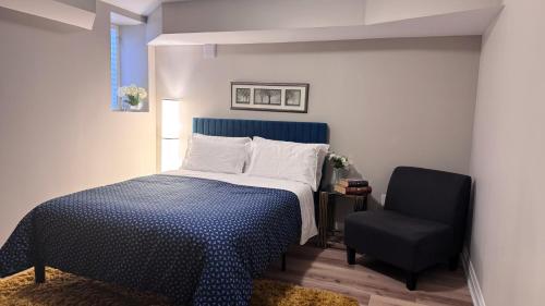 a bedroom with a bed and a black chair at Luxury 2-Bedroom Designer Suite Richmond Hill Lake Wilcox in Richmond Hill