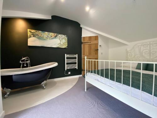 La salle de bains est pourvue d'une baignoire et d'un lit. dans l'établissement Hen Stablau, à Llanfihangel-Glyn-Myfyr