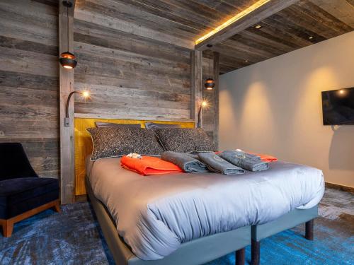 ein Schlafzimmer mit einem Bett mit einer Holzwand in der Unterkunft Appartement d'exception 7 pièces pour 12 pers, espace bien-être à Avoriaz - FR-1-314-102 in Avoriaz
