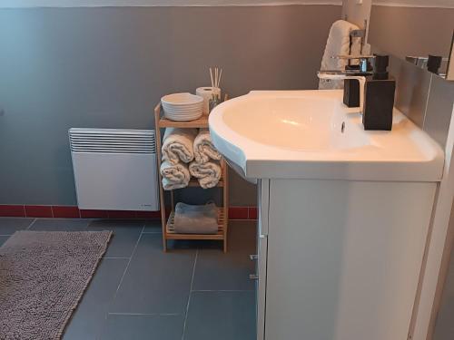 a bathroom with a sink and a shelf with towels at Gîte spacieux avec salle de jeux, tennis et cheminée, idéal pour familles et amis jusqu'à 15 pers. - FR-1-410-223 in Saint-Jean-de-la-Motte