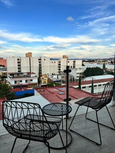 two chairs and a table on top of a roof at Departamento completo con balcon en Av Carranza in San Luis Potosí