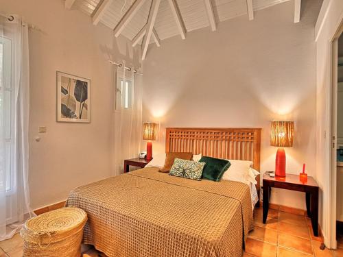 a bedroom with a large bed with two lamps at Charmante Villa "Coquelicot" à Orient Baie, Proche Plage et Commerces, Confort et Détente Garantis - FR-1-734-10 in Orient Bay