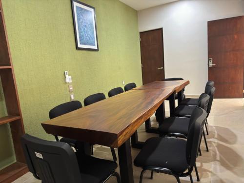 einen Konferenzraum mit einem langen Holztisch und Stühlen in der Unterkunft Aeropuerto Express Huatulco in Bahías de Huatulco