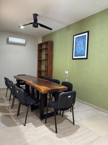a dining room with a wooden table and black chairs at Aeropuerto Express Huatulco in Bahías de Huatulco