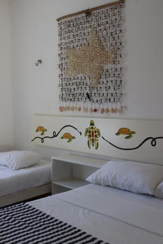 a bedroom with two beds and a painting on the wall at CASA KINICH SISAL in Sisal