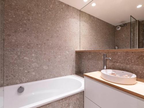 a bathroom with a bath tub and a sink at Appartement chalet familial, 8 personnes, 3 balcons, proche pistes et commerces - FR-1-314-120 in Morzine