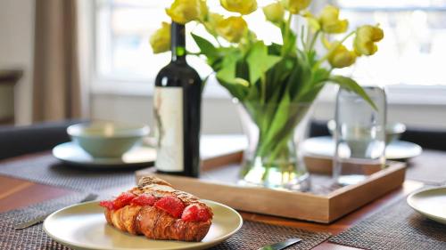 a table with a plate of food and a bottle of wine at Hearth Home Brick Oven Karaoke 4 Bedroom fits 8 in Columbus